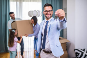 familia feliz mudandose su nuevo hogar agente inmobiliario que muestra llaves apartamento sonrie
