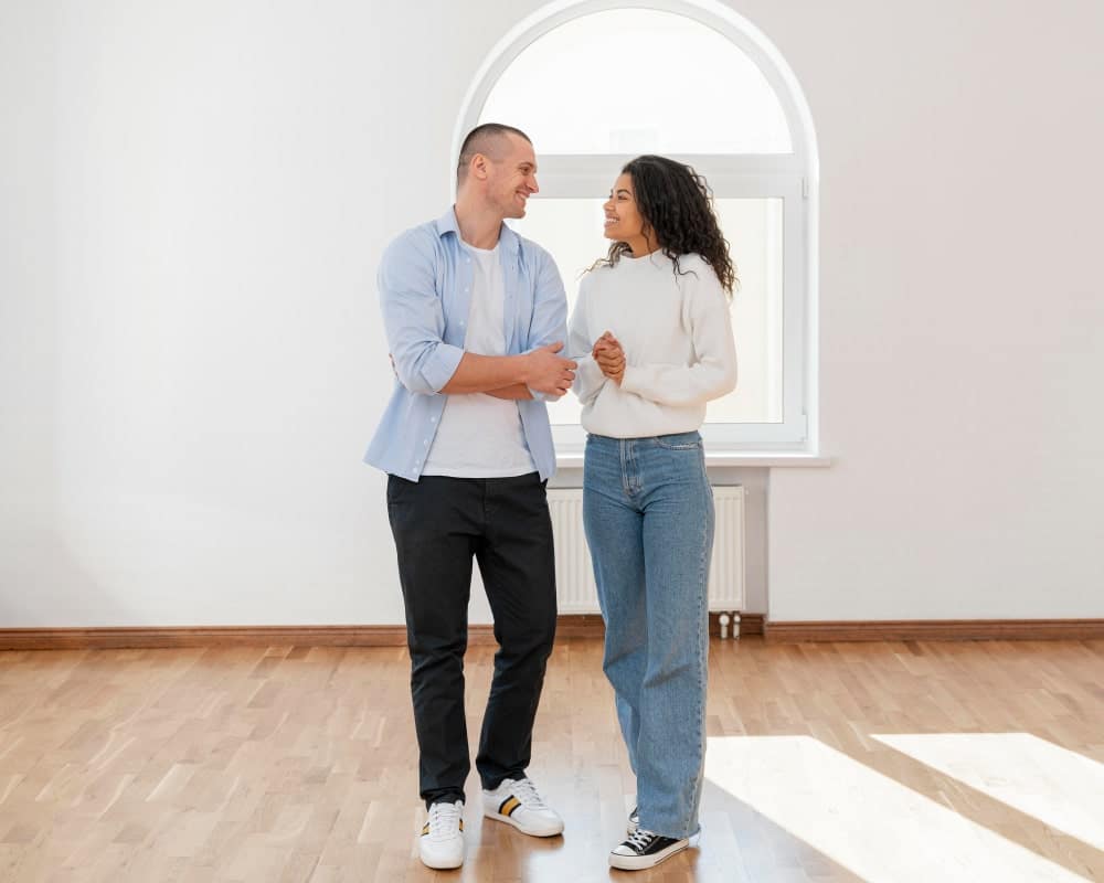 vista frontal pareja sonriente su nueva casa vacia min